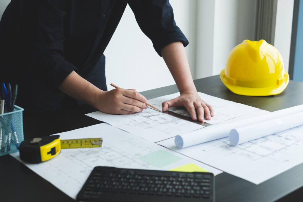 Architects or engineers working construction and drawing construction plans, printing